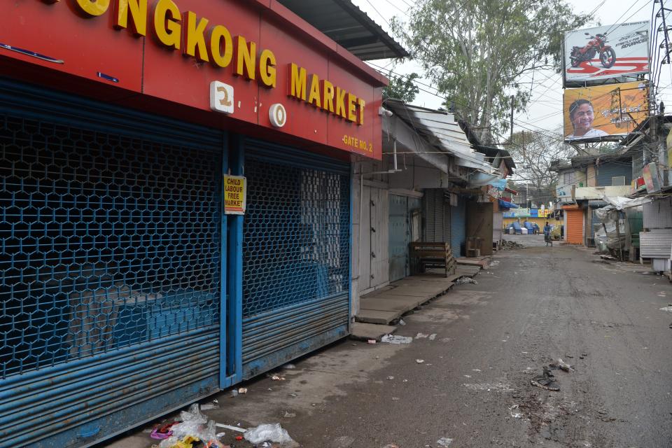 A man rides a bicycle in front of closed shops during a one-day Janata (civil) curfew imposed as a preventive measure against the COVID-19 coronavirus, in Siliguri on March 22, 2020. - Nearly one billion people around the world were confined to their homes, as the coronavirus death toll crossed 13,000 and factories were shut in worst-hit Italy after another single-day fatalities record. (Photo by DIPTENDU DUTTA / AFP) (Photo by DIPTENDU DUTTA/AFP via Getty Images)