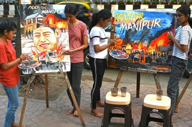 Unos estudiantes de arte le dan los últimos retoques a unos cuadros sobre las protestas de grupos tribales en el estado indio de Manipur, el 5 de mayo de 2023 en Bombay