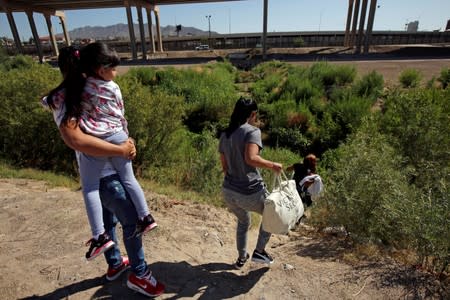 FILE PHOTO: Migrants from Cuba are seen on the banks of the Rio Bravo river as they cross illegally into the United States to turn themselves in to request asylum in El Paso, Texas, as seen from Ciudad Juarez