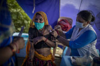 An elderly woman reacts as a health worker inoculates her during a special vaccination drive for homeless and migrant workers against COVID-19 in New Delhi, India, Wednesday, Sept. 15, 2021. (AP Photo/Altaf Qadri)