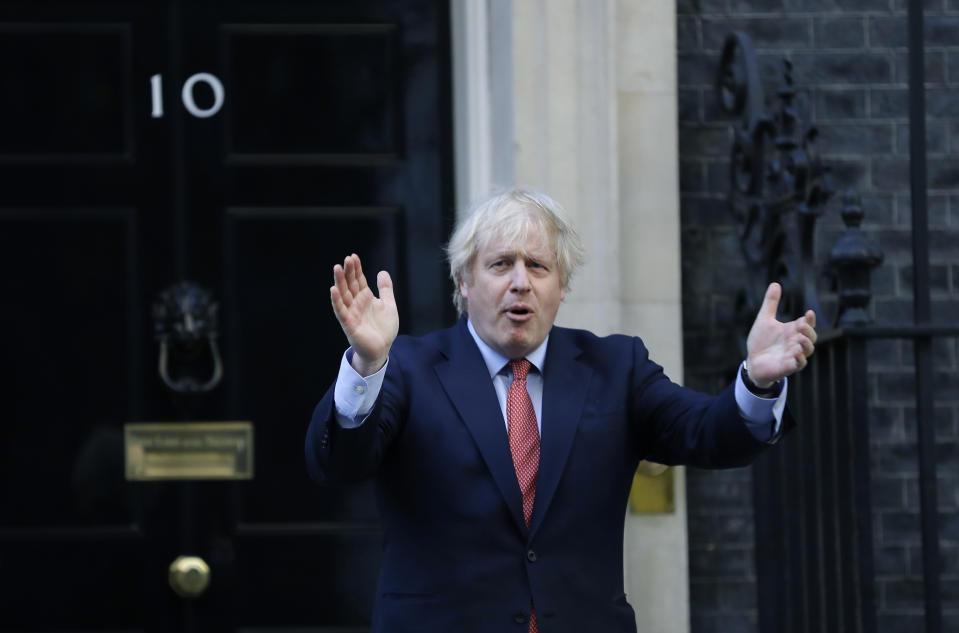 Britain's Prime Minister Boris Johnson applauds on the doorstep of 10 Downing Street in London during the weekly "Clap for our Carers" Thursday, May 28, 2020. The COVID-19 coronavirus pandemic has prompted a public display of appreciation for care workers. The applause takes place across Britain every Thursday at 8pm local time to show appreciation for healthcare workers, emergency services, armed services, delivery drivers, shop workers, teachers, waste collectors, manufacturers, postal workers, cleaners, vets, engineers and all those helping people with coronavirus and keeping the country functioning while most people stay at home in the lockdown. (AP Photo/Kirsty Wigglesworth)