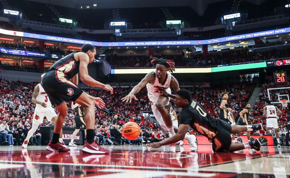 Louisville's Kamari Lands, center,  scrambles with Florida State guard Chandler Jackson, right, for a loose ball in the second half. The Cards lost 81-78 to the Seminoles at the KFC Yum! Center Saturday afternoon. Feb 4, 2023