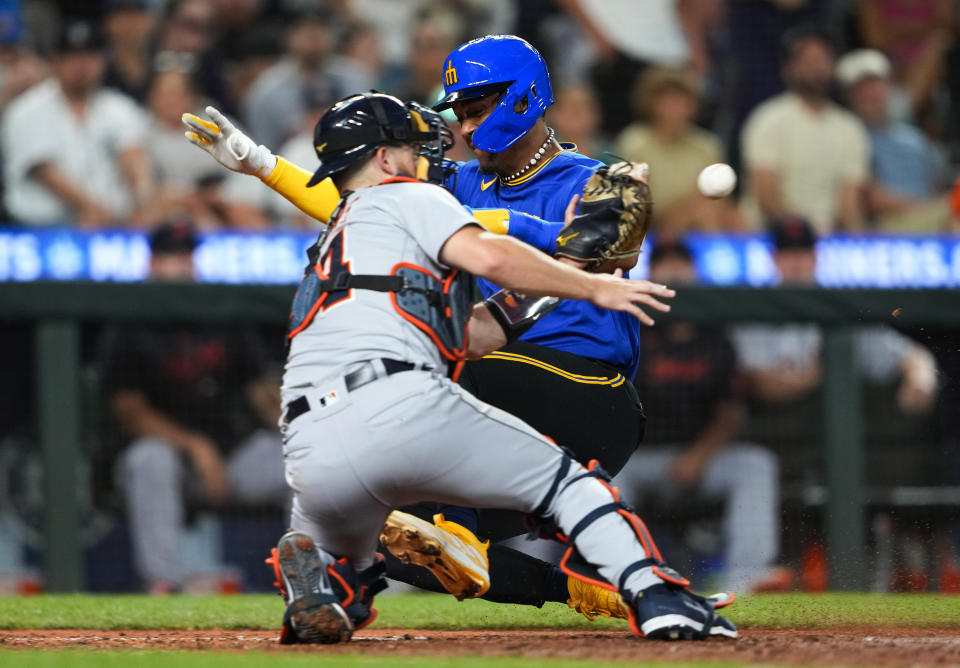 Seattle Mariners' Julio Rodriguez slides in to home plate to score as Detroit Tigers catcher Jake Rogers looks for the throw during the eighth inning of a baseball game Friday, July 14, 2023, in Seattle. Rodriguez was initially ruled out at home but the call was overturned after a challenge by the Mariners. (AP Photo/Lindsey Wasson)