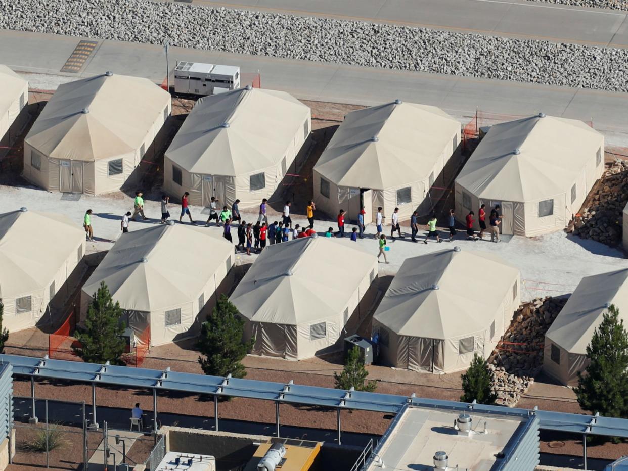 Immigrant children, many of whom have been separated from their parents under a new 'zero tolerance' policy by the Trump administration, are shown walking in single file between tents in their compound next to the Mexican border in Tornillo, Texas: REUTERS/Mike Blake