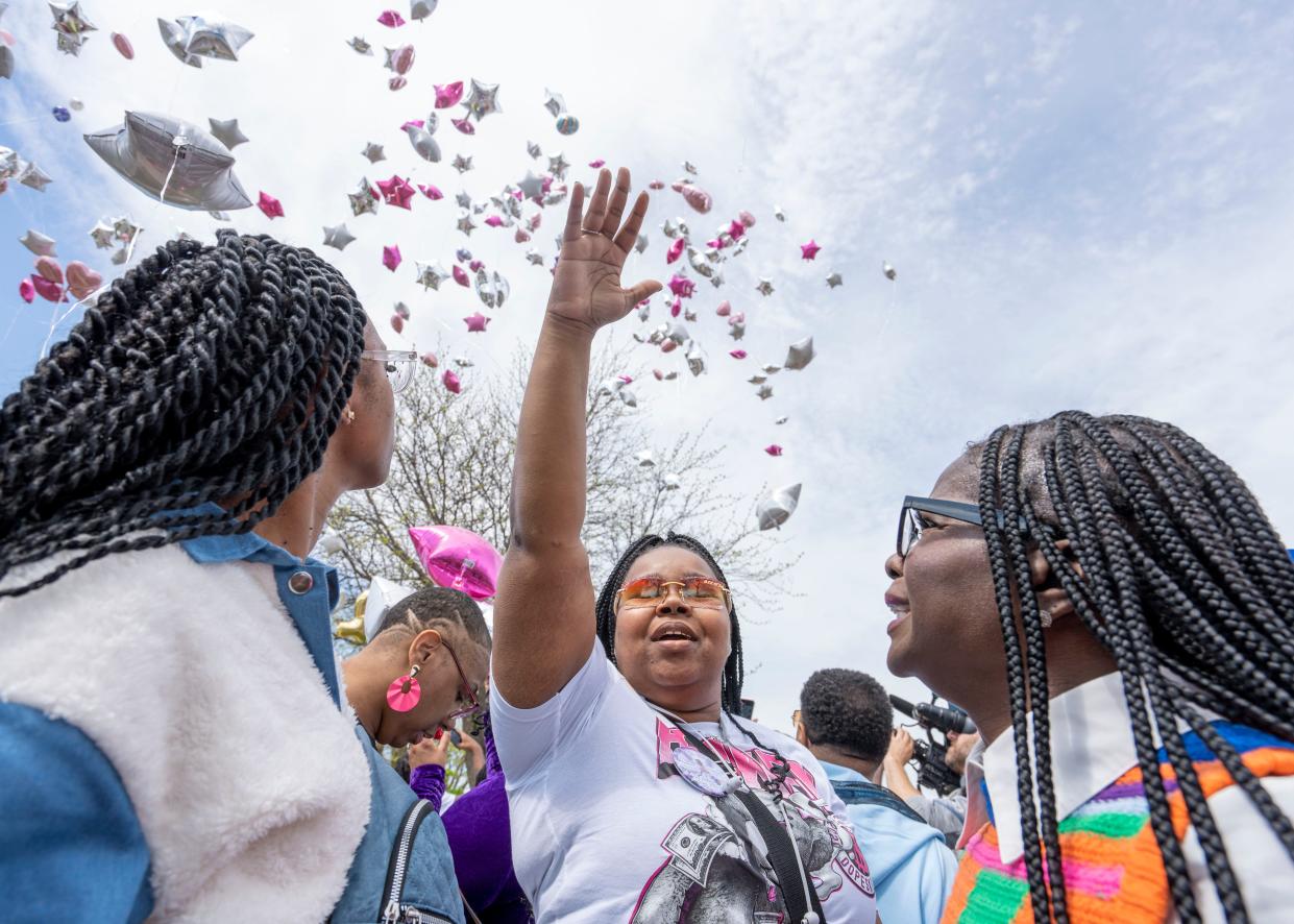 (Center) Erica Hymes, grandmother of Zekani Hymes-Wilson, holds her hand up during a balloon release at the scene of the accident, that killed the 4-year-old and injured her mother at the intersection of North Teutonia Avenue and West Vera Avenue, on Saturday May 4, 2024 in Milwaukee, Wis.
