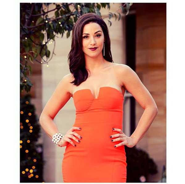 A photo of The Bachelor Australia 2015 contestant Jacinda Gugliemino wearing an orange strapless dress on set.