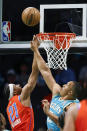 Oklahoma City Thunder guard Aaron Wiggins (21) shoots against Charlotte Hornets forward Grant Williams during the first half of an NBA basketball game in Charlotte, N.C., Sunday, April 7, 2024. (AP Photo/Nell Redmond)