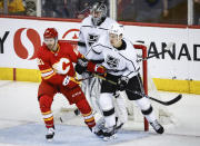 Los Angeles Kings defenseman Andreas Englund (5) and Calgary Flames forward Kevin Rooney (21) jostle for position as goalie David Rittich (31) watches during the second period of an NHL hockey game Saturday, March 30, 2024, in Calgary, Alberta. (Jeff McIntosh/The Canadian Press via AP)