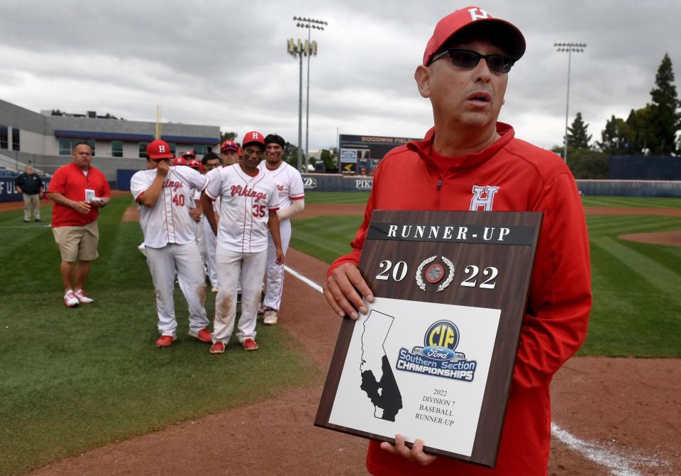 Hueneme head coach Manny Lara holds the runner-up plaque after the Vikings lost to Baldwin Park 4-2 in the CIF-SS Division 7 title game at Cal State Fullerton on Friday, May 20, 2022.