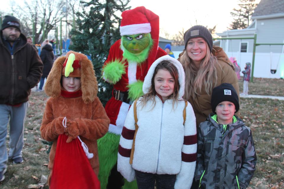 Ari (8), Cruz (5) and Leah Haywood pose for a photo with the Grinch during the first annual Van Meter Holiday Tree Lighting Festival on Saturday, Dec. 3, 2022, at Memorial Park.