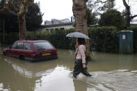 <p>Eine Frau läuft durch die überfluteten Straßen von Villennes-sur-Seine, einer Ortschaft westlich von Paris. Schwere Regenfälle haben dazu geführt, dass Gärten und Straßen überschwemmt wurden. (Bild: AP Photo) </p>