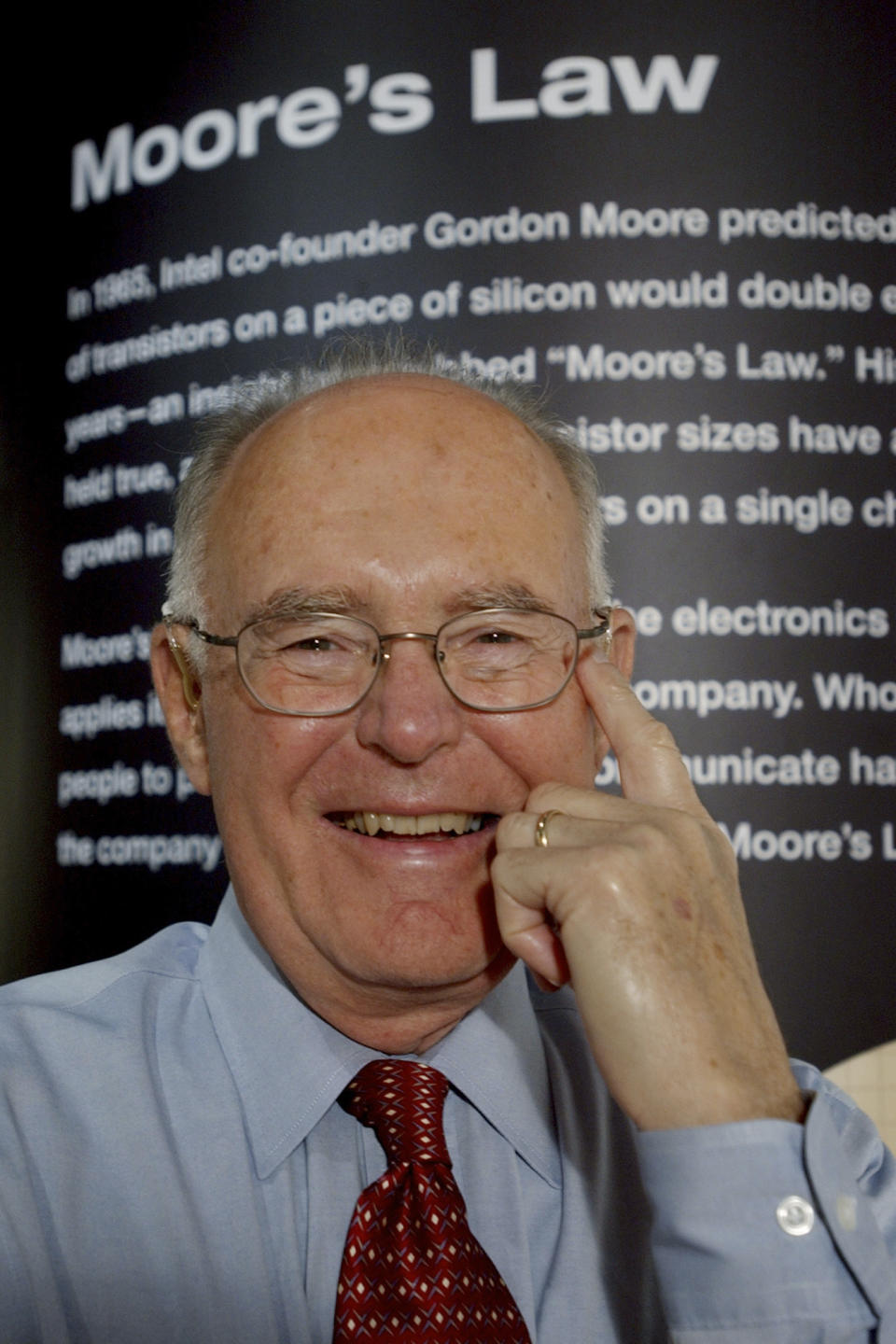 FILE - Intel Corp. co-founder Gordon Moore smiles next to a wall at Intel headquarters in Santa Clara, Calif., Wednesday, March 9, 2005. Moore, the Intel Corp. co-founder who set the breakneck pace of progress in the digital age with a simple 1965 prediction of how quickly engineers would boost the capacity of computer chips, has died. He was 94. Intel and the Gordon and Betty Moore Foundation say Moore died Friday, March 24, 2023 at his home in Hawaii. (AP Photo/Paul Sakuma, File)