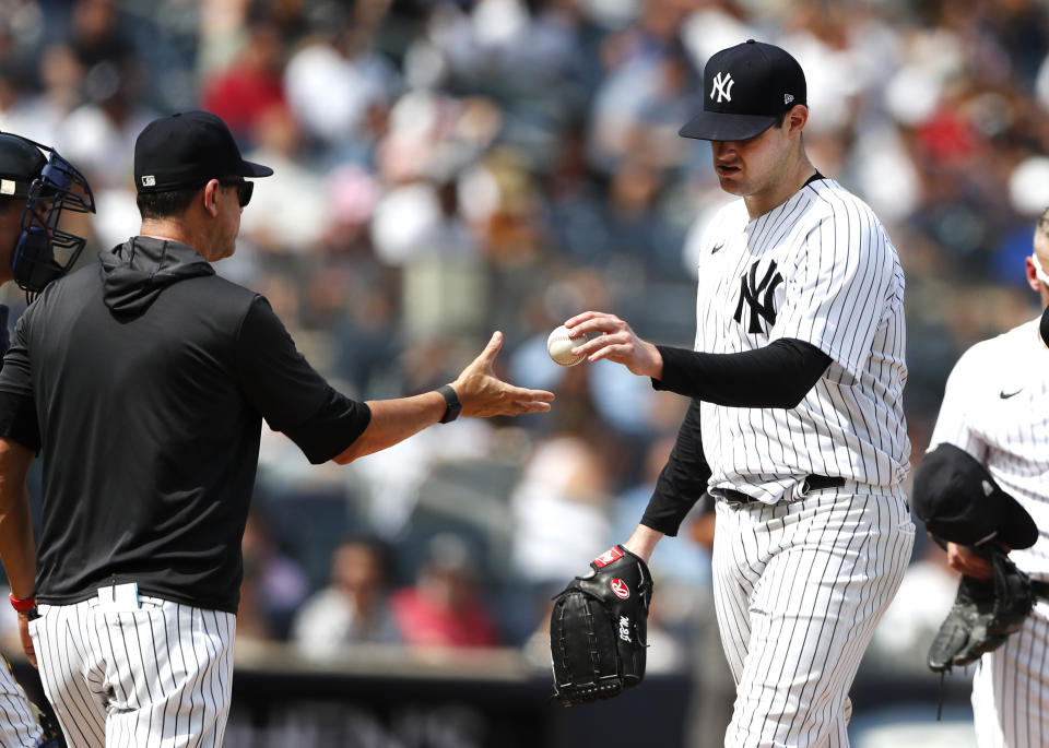 New York Yankees manager Aaron Boone, front left, takes the ball from starting pitcher Jordan Montgomery during the fifth inning of a baseball game against the Kansas City Royals, Sunday, July 31, 2022, in New York. (AP Photo/Noah K. Murray)