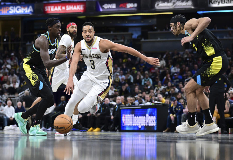 New Orleans Pelicans guard CJ McCollum (3) drives between Indiana Pacers forward Pascal Siakam, left, and guard Andrew Nembhard, right, during the second half of an NBA basketball game Wednesday, Feb. 28, 2024, in Indianapolis. (AP Photo/Marc Lebryk)