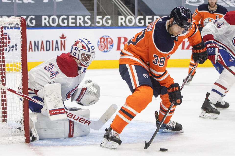 Edmonton Oilers' Alex Chiasson (39) tries to tip the puck in past Montreal Canadiens goalie Jake Allen (34) during second-period NHL hockey game action in Edmonton, Alberta, Monday, Jan. 18, 2021. (Jason Franson/The Canadian Press via AP)