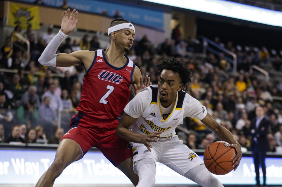 Northern Kentucky guard Jalen Tate (11) drives against Northern Kentucky guard Paul Djoko (2) during the first half of an NCAA college basketball game for the Horizon League men's tournament championship in Indianapolis, Tuesday, March 10, 2020. (AP Photo/Michael Conroy)