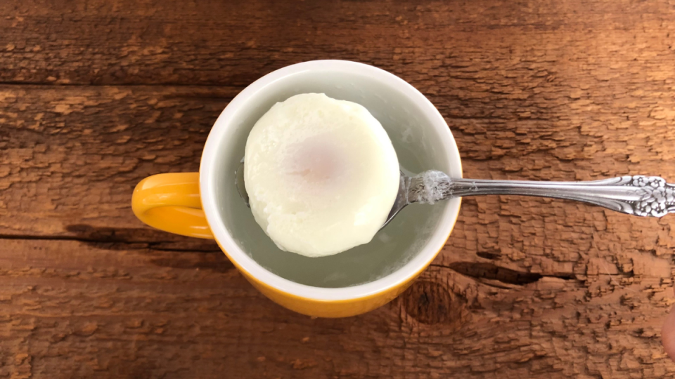 microwaved poached egg in a yellow cup