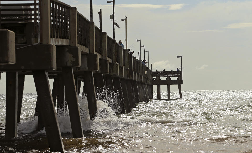A group of people fish at Dania Beach Pier on Saturday, Aug. 31, 2019 at Dania Beach, Fla. The latest forecast says Hurricane Dorian is expected to stay just off shore of Florida and skirt the coast of Georgia, with the possibility of landfall still a threat on Wednesday, and then continuing up to South Carolina early Thursday. (David Santiago/Miami Herald via AP)