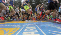 FILE - Runners cross the start line of the 123rd Boston Marathon on Monday, April 15, 2019, in Hopkinton, Mass. Once a year for the last 100 years, Hopkinton becomes the center of the running world, thanks to a quirk of geography and history that made it the starting line for the world's oldest and most prestigious annual marathon. (AP Photo/Stew Milne, File)