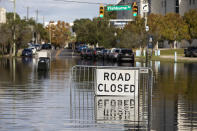 A road closed sign tells motorist to not pass through the flood waters at the intersection of Fishburne St. and Hagood Ave. as a king tide rolls into historic Charleston, S.C. Sunday, Nov. 15, 2020. Charleston has remained relatively unscathed this hurricane season. That means more time to mull a $1.75 billion proposal by the Army Corps of Engineers that features a sea wall along the city's peninsula to protect it from deadly storm surge during hurricanes. (AP Photo/Mic Smith)