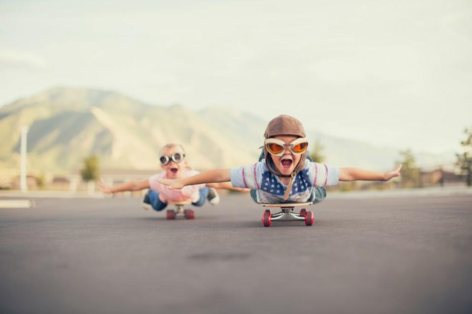 Niños volando en un monopatín