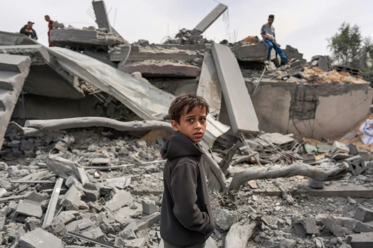 Un garçon palestinien devant les décombres d'un bâtiment, après un bombardement israélien, le 29 mars 2024 dans le camp de réfugiés de Maghazi, dans le centre e la bande de Gaza, où une guerre oppose Israël au mouvement islamiste Hamas (-)