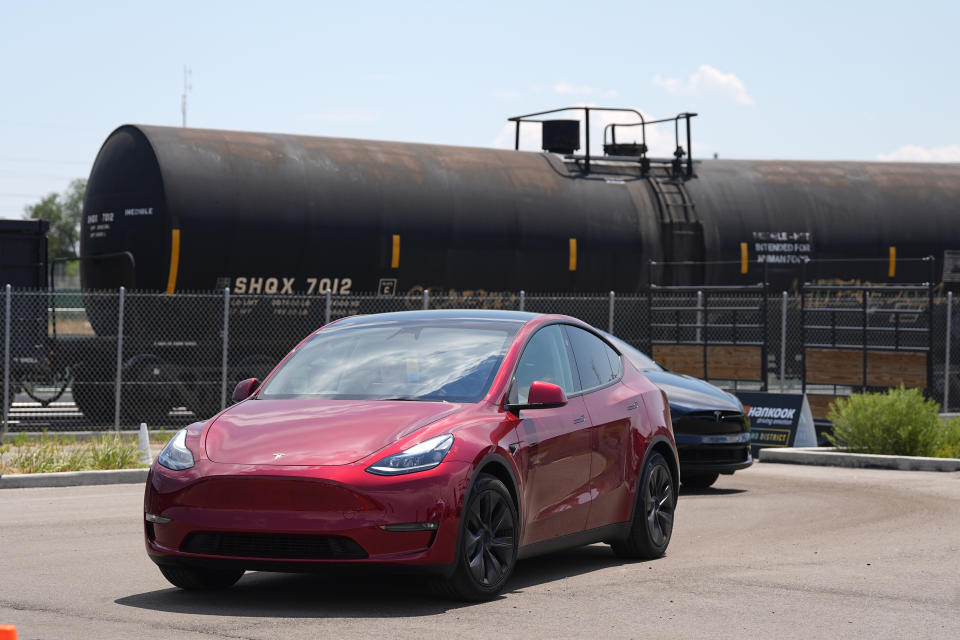 FILE - Drivers guide 2024 a Tesla Model 3 sedan and Model X utility vehicle, rear, along a test track at the Electrify Expo in The Yards on July 14, 2024, in north Denver. (AP Photo/David Zalubowski, File)