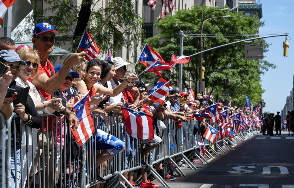 Spectators hold hundreds of flags of Puerto Rico as they watch the National Puerto Rican Day Parade Sunday, June 9, 2019, in New York. (AP Photo/Craig Ruttle)