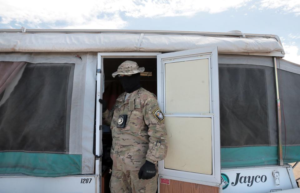 A United Constitutional Patriot who goes by “Stinger” prepares to leave one of the camp’s trailers for a patrol along the border in Anapra, New Mexico.