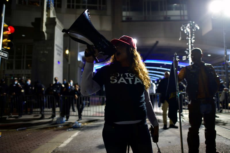 A supporter of U.S. President Donald Trump chants "Dead men don't vote" while taunting activists across the street from where votes are being counted n Philadelphia