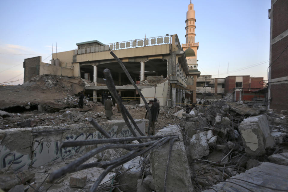 People visit the site of Monday's suicide bombing after authorities finished the rescue operation, in Peshawar, Pakistan, Tuesday, Jan. 31, 2023. A suicide bombing that struck inside a mosque at a police and government compound in northwest Pakistan reflects "security lapses," current and former officials said as the death toll from the devastating blast climbed to 100 on Tuesday. (AP Photo/Muhammad Sajjad)