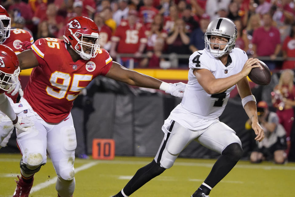 Las Vegas Raiders quarterback Derek Carr (4) scrambles away from Kansas City Chiefs defensive tackle Chris Jones (95) during the second half of an NFL football game Monday, Oct. 10, 2022, in Kansas City, Mo. (AP Photo/Ed Zurga)