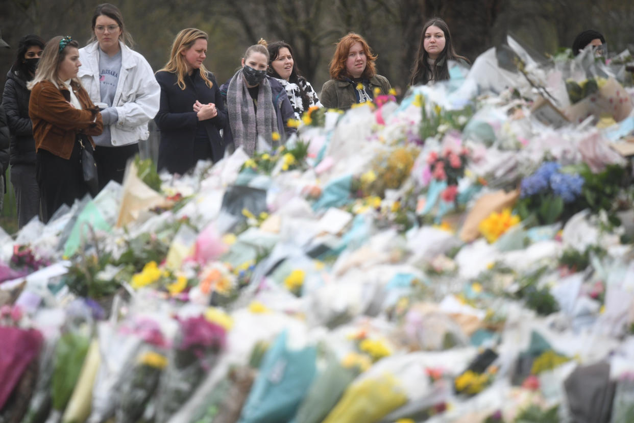 People viewing floral tributes left at the bandstand in Clapham Common, London, for Sarah Everard. Pc Wayne Couzens, 48, appeared at the Old Bailey in London charged with the kidnap and murder of the 33-year-old. Picture date: Sunday March 21, 2021.