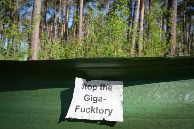 A piece of paper with the words "Stop the Giga-Fucktory" is stuck to a toad protection fence near the eastern part of the Tesla Gigafactory site and the protest camp in the forest. On 16 May, municipal representatives from Gruenheide approved a development plan that clears the way for an expansion of the Tesla factory. The car manufacturer wants to expand its site to include a freight yard and logistics areas. Soeren Stache/dpa