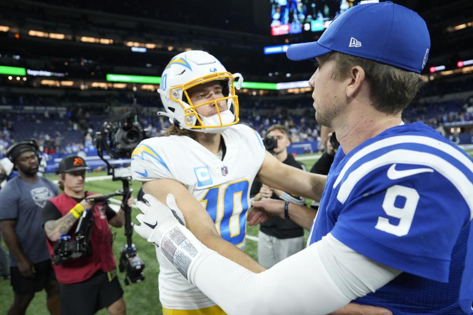 Los Angeles Chargers quarterback Justin Herbert (10) greets Indianapolis Colts quarterback Nick Foles (9) following an NFL football game, Monday, Dec. 26, 2022, in Indianapolis. (AP Photo/AJ Mast)