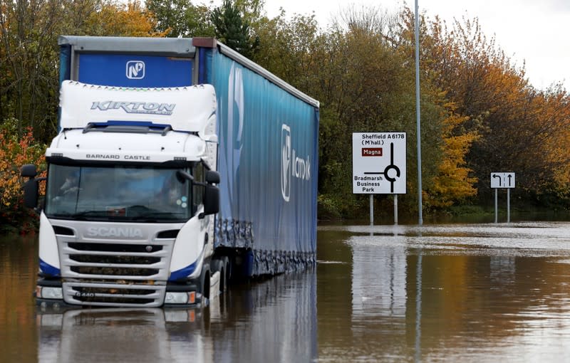 A driver sits in his stranded truck at a flooded road in central Rotherham, near Sheffield