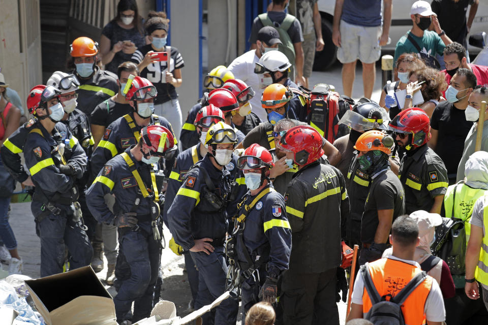 French and Lebanese firemen search in the rubble of a building after the Tuesday explosion at the seaport of Beirut, in Beirut, Lebanon, Thursday, Aug. 6, 2020. Lebanese officials targeted in the investigation of the massive blast that tore through Beirut sought to shift blame for the presence of explosives at the city's port, and the visiting French president warned that without serious reforms the country would "continue to sink." (AP Photo/Hassan Ammar)