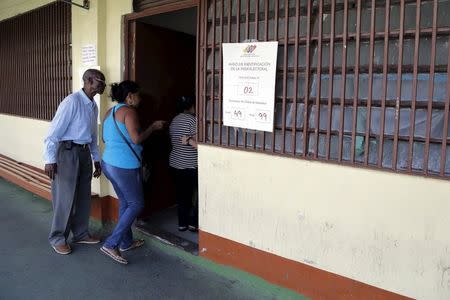 People enter to a polling station to cast their vote during opposition coalition primaries for parliamentary election in Caracas May 17, 2015. REUTERS/Marco Bello