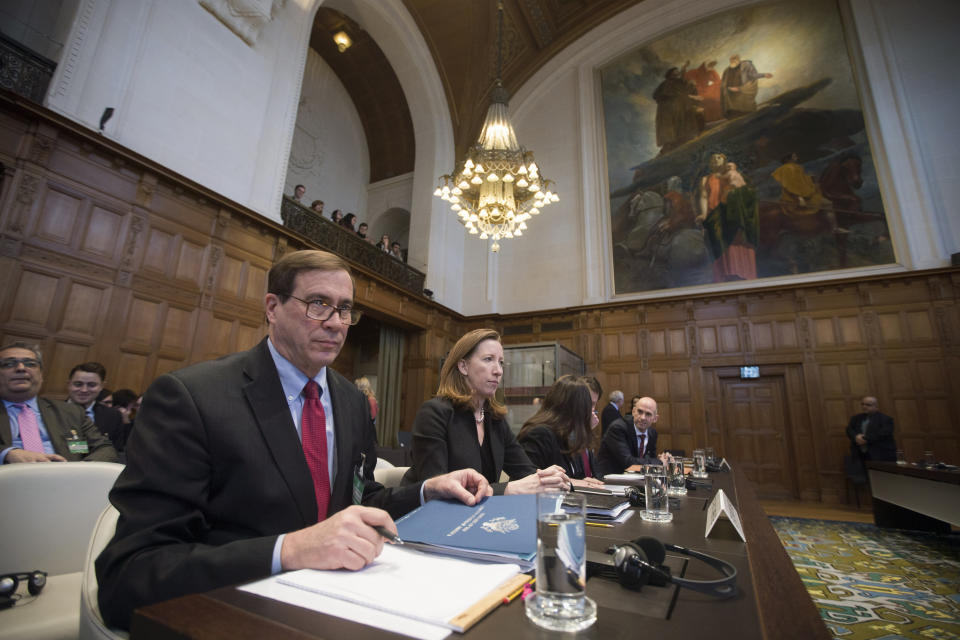 FILE- In this Wednesday, Feb. 13, 2019, file photo, Richard Visek, left, agent of the U.S.A. and members of the U.S. delegation wait for judges to enter the International Court of Justice, or World Court, in The Hague, Netherlands. The United Nations highest court is ruling on U.S. objections to its jurisdiction in in a case brought by Iran against Washington in a bid to end sanctions re-imposed by the Trump administration in 2018 after pulling out of an international deal aimed at curtailing Tehran's nuclear program.(AP Photo/Peter Dejong, File)