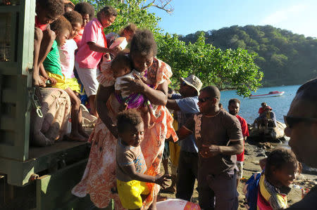 Residents carry their possessions as they prepare to board a boat at Lolowai Port as they evacuate due to the Manaro Voui volcano continuing to emenate smoke and ash on Vanuatu's northern island of Ambae in the South Pacific, October 1, 2017. Picture taken October 1, 2017. REUTERS/Ben Bohane