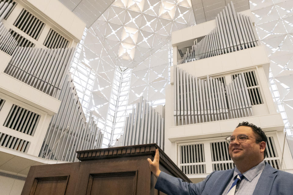 David La'O Ball, organist and head of music ministry at Christ Cathedral, stands by the Hazel Wright organ in Garden Grove, Calif., Tuesday, Feb. 15, 2022. Nearly a decade and $3 million later, “Hazel” is back in the shimmering sanctuary and heavenly chords from her pipes are once again ringing out in its vaulted nave. (AP Photo/Damian Dovaragnes)