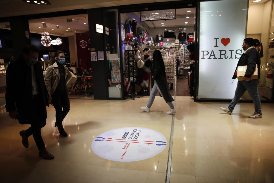 People walk in a shopping mall Monday, May 11, 2020 in Paris. The French began leaving their homes and apartments for the first time in two months without permission slips as the country cautiously lifted its lockdown. Clothing stores, coiffures and other businesses large and small were reopening on Monday _ with strict precautions to keep the coronavirus at bay. (AP Photo/Francois Mori)