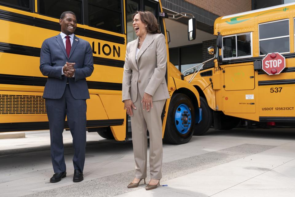 FILE - Vice President Kamala Harris, right, laughs with Environmental Protection Agency Administrator Michael Regan, during a tour of electric school buses at Meridian High School in Falls Church, Va., May 20, 2022. Nearly 400 school districts spanning all 50 states are receiving grants totaling nearly $1 billion to purchase nearly 2,500 "clean" school buses under a new federal program. The Biden administration is making the grants available as part of a wider effort to accelerate the transition to zero emission vehicles and reduce air pollution near schools and communities. (AP Photo/Jacquelyn Martin, File)