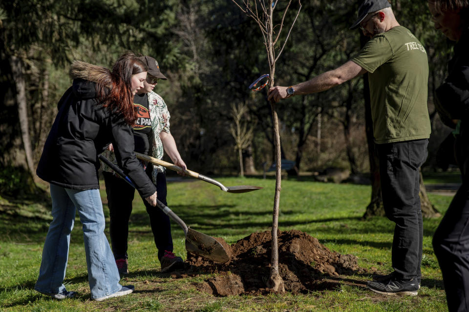 Dozens gathered at Nadaka Nature Park in Gresham, Ore., Saturday morning, March 16, 2024, to hold a tree planting event in memory of those who died during the heatwave of 2021. Multiple trees were planted across the Multnomah County in memory of each life that was lost. Family members and friends of those who passed participated in the event. (Mark Graves/The Oregonian via AP)