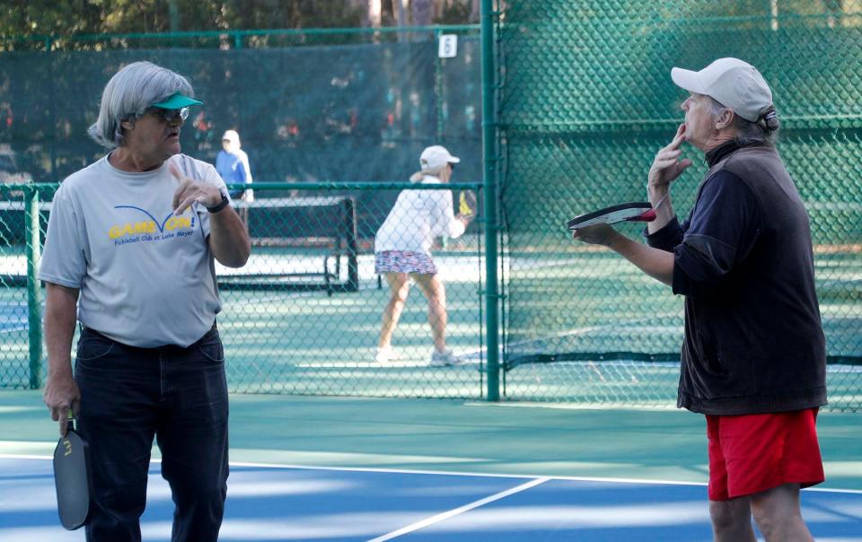 Ricky Snipes, left, and Terry Patterson use sign language to communicate as they play pickleball at The Landings Club's Franklin Creek Tennis Center on Oct. 20, 2022.