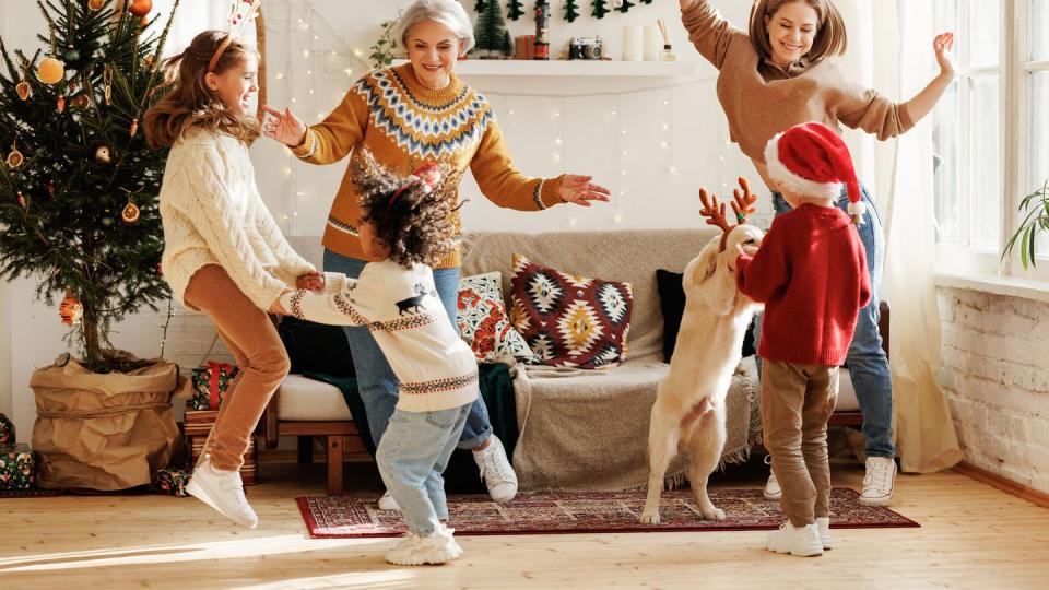 happy multiracial family with three kids and golden retriever have fun on christmas day at home