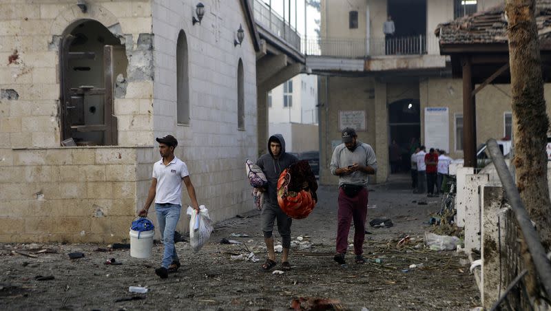 Palestinians carry belongings as they leave al-Ahli hospital, which they were using as a shelter, in Gaza City on Wednesday, Oct. 18, 2023. The Hamas-run Health Ministry says an Israeli airstrike caused the explosion that killed hundreds at al-Ahli hospital, but the Israeli military says it was a misfired Palestinian rocket.