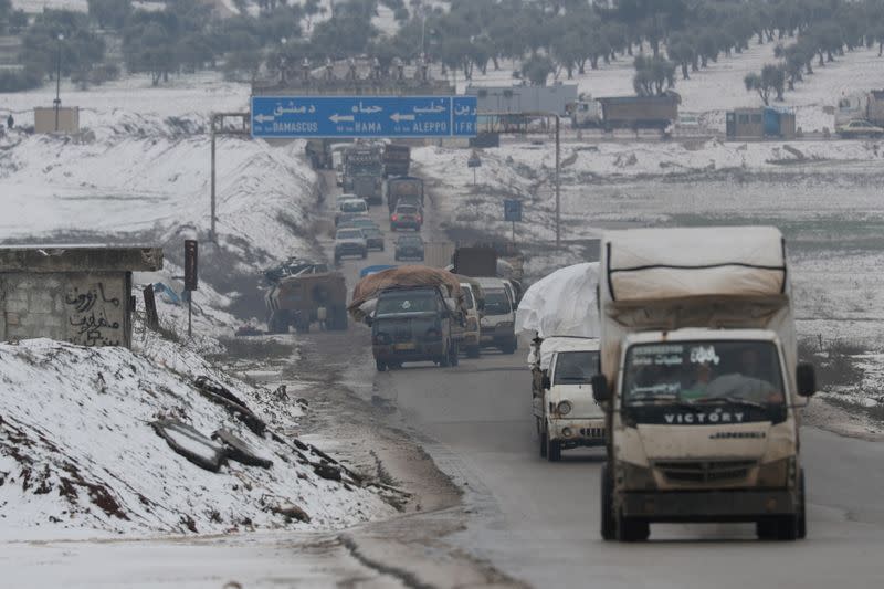 Desplazados viajan en camiones con sus pertenencias en Azaz, Siria.