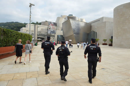 Armed Basque police patrol next to the Guggenheim Museum in Bilbao, Spain August 18, 2017, after a suspected Islamist militant drove a van into crowds in Barcelona. REUTERS/Vincent West