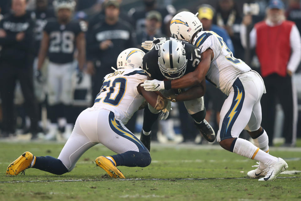 <p>Jalen Richard #30 of the Oakland Raiders is tackled by Adrian Phillips #31 and Desmond King #20 of the Los Angeles Chargers during their NFL game at Oakland-Alameda County Coliseum on November 11, 2018 in Oakland, California. (Photo by Ezra Shaw/Getty Images) </p>